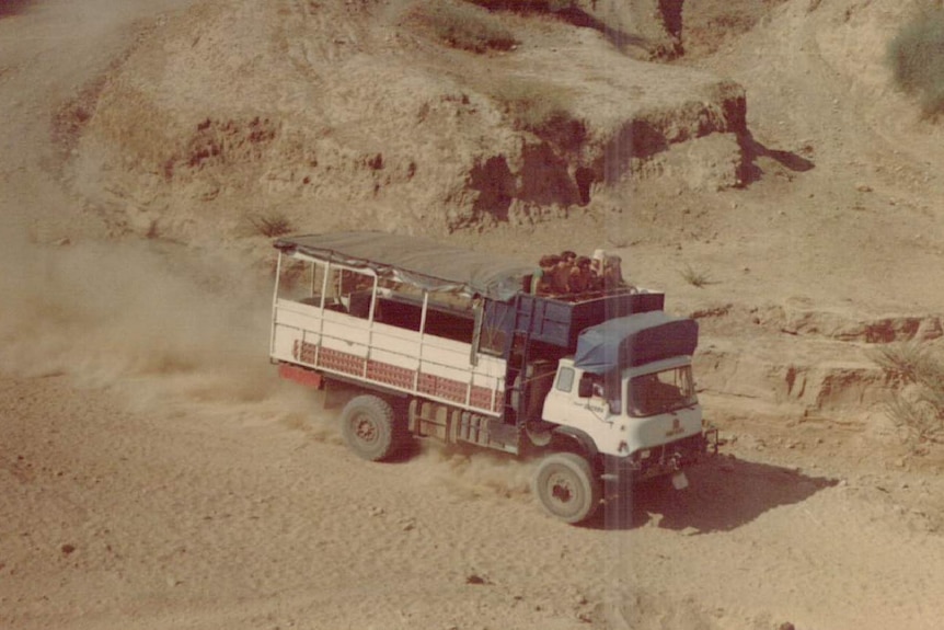 An aged holiday photo shows a truck driving through the desert.