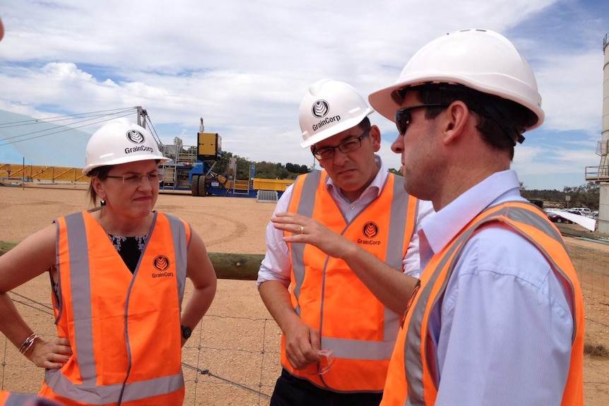 Le ministre des Transports de l'époque victorienne Jacinta Allan, le premier ministre Daniel Andrew et Lance Brown, de GrainCorp, à côté de la ligne de fret ferroviaire.