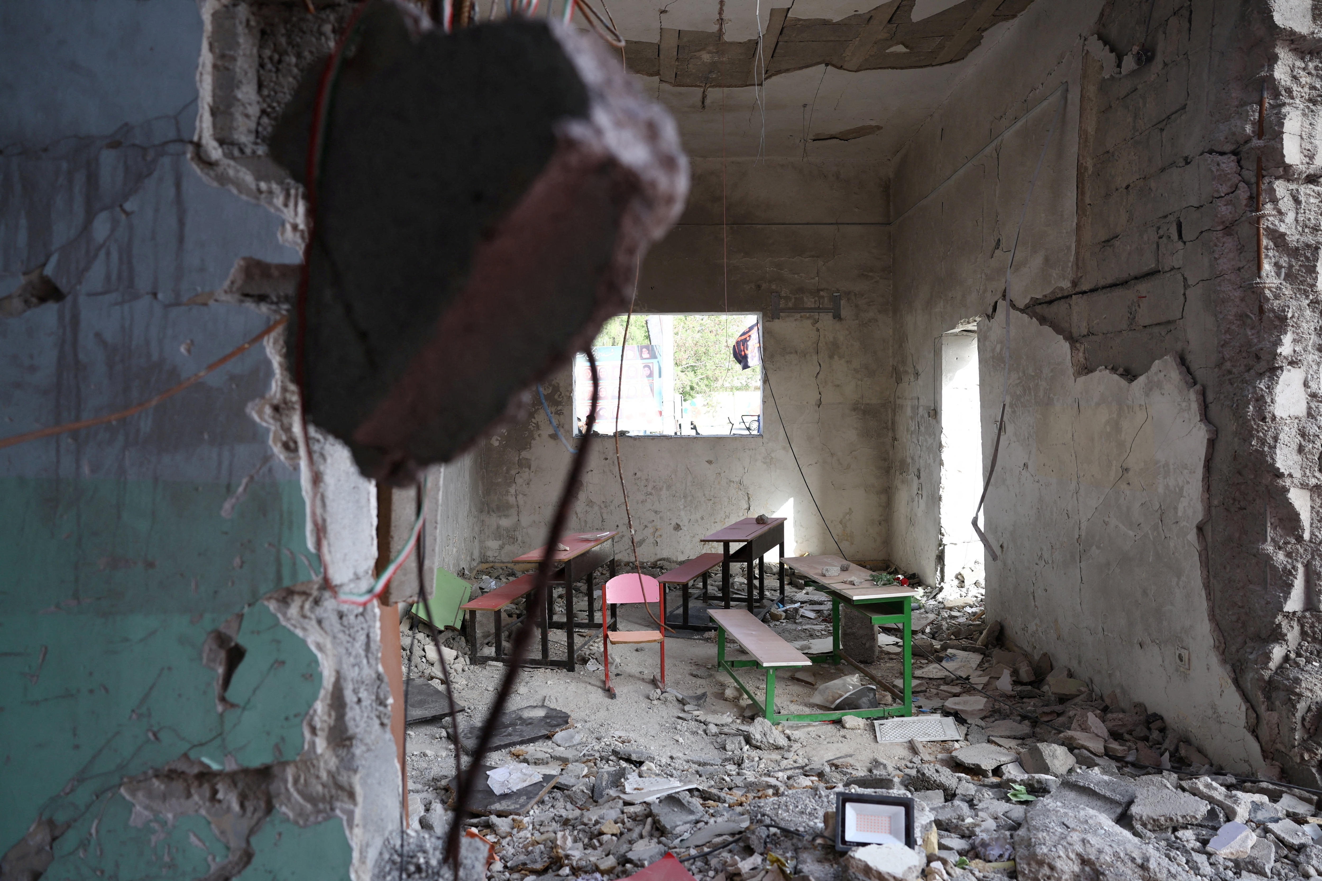 A pink chair, table and bench inside a classroom destroyed by a military strike.