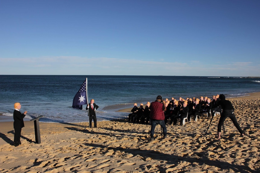 A group of Trump impersonators being filmed and photographed on the beach in Newcastle.