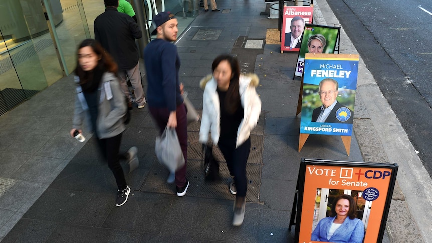 People pass federal election 2016 pre-poll station