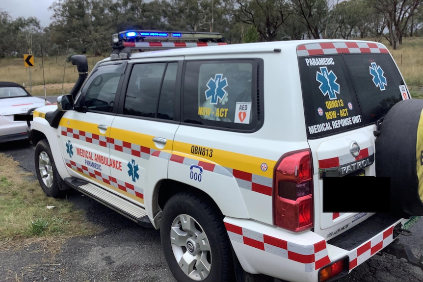 A white 4WD with red and blue lights on the roof and stickers reading "paramedic" and "medical ambulance".