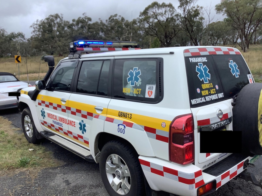 A white 4WD with red and blue lights on the roof and stickers reading "paramedic" and "medical ambulance".