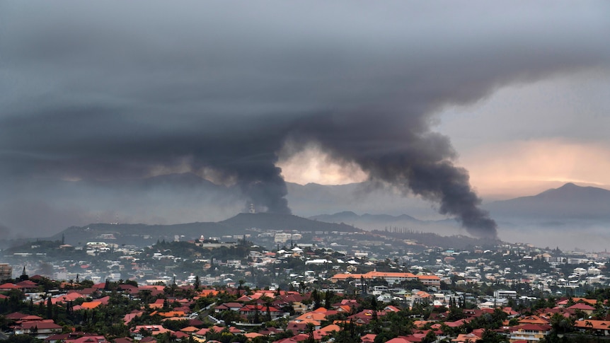Smoke rises over city of Noumea, in New Caledonia.