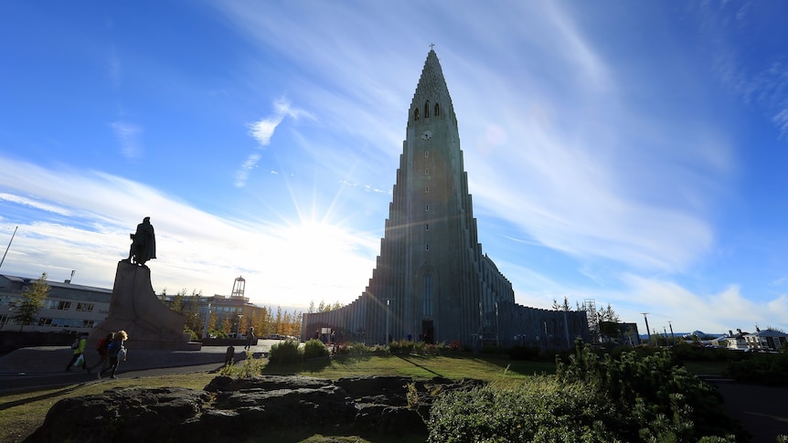 Hallgrímskirkja Cathedral is seen before blue skies as the sun shines over Reykjavik, Iceland