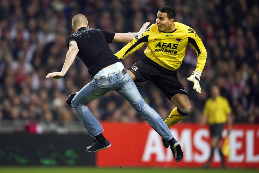 AZ Alkmaar goalkeeper, Esteban, kicks a man who attacked him from behind.