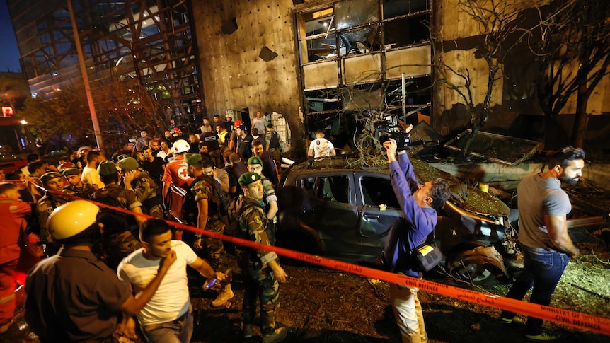 Lebanese security and emergency services cordon off a damaged building.