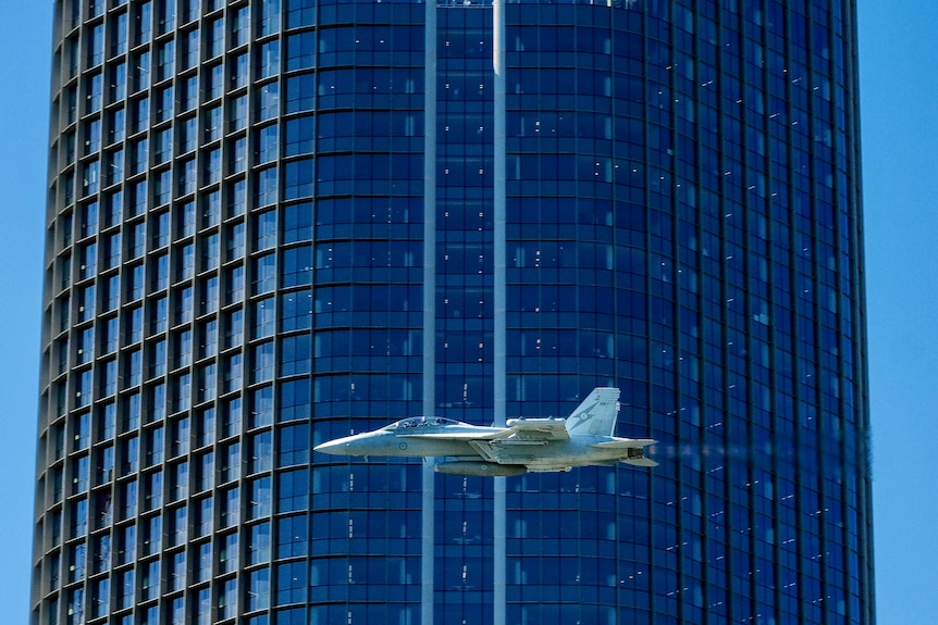 A plane flies close to a building in South Bank, Brisbane.