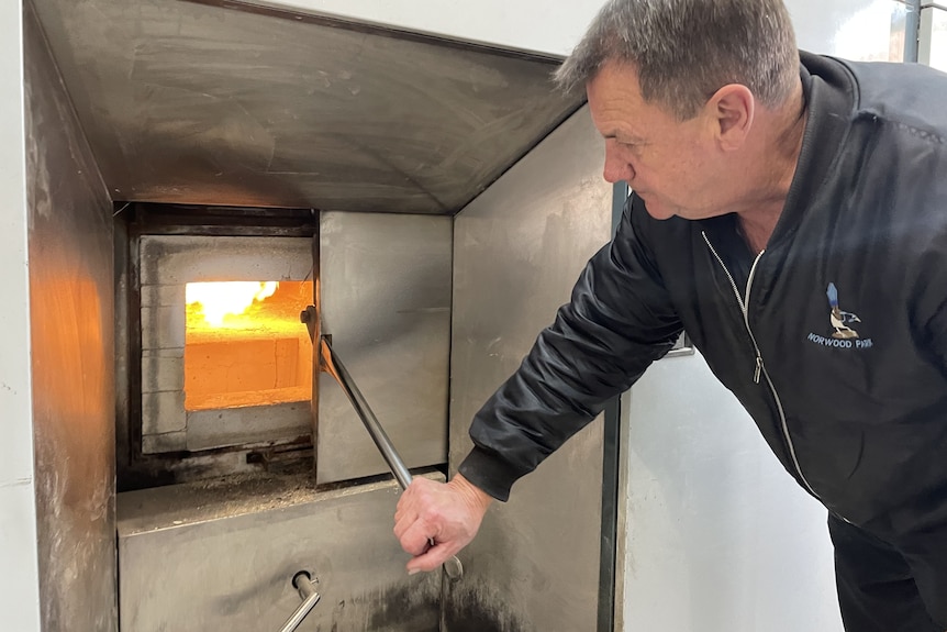 a man looking into a cremation furnace