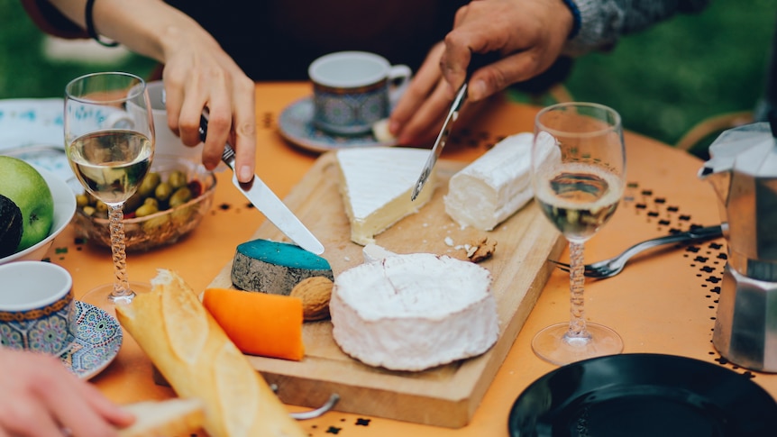 Cheese and wine on a table as people have lunch