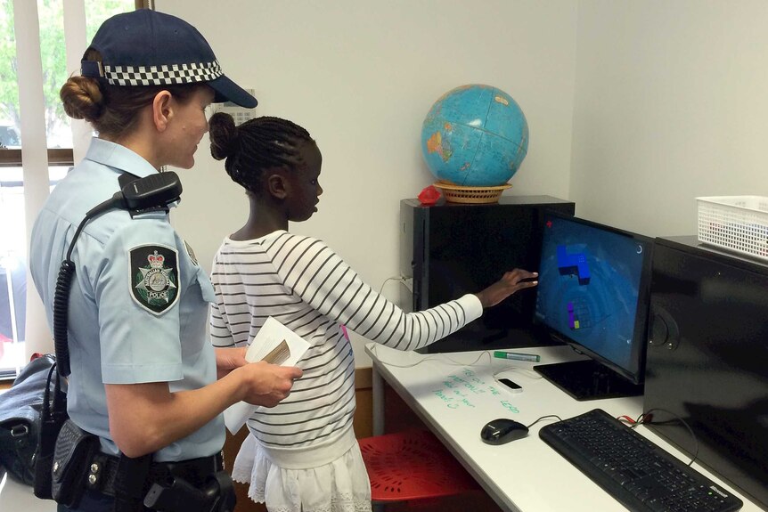 Yayei Otuk, 10, and a female police officer at the Computer Clubhouse.