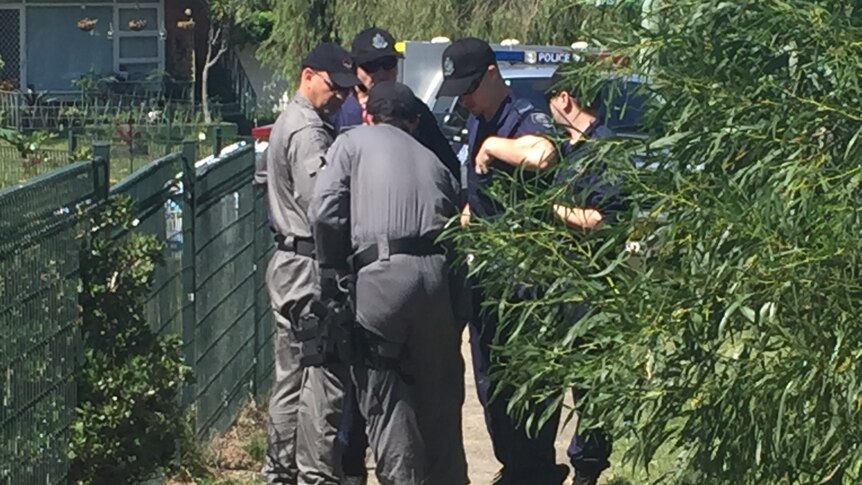 Officers gather outside a unit complex at Maroubra as a police operation took place.