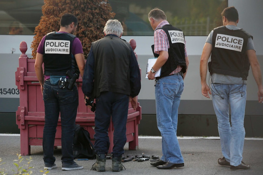 French police stand on the train platform near gun cartridges and a backpack in Arras, France