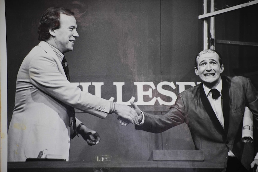 A black and white photo of Mike Willesee shaking Norman Gunston's hand