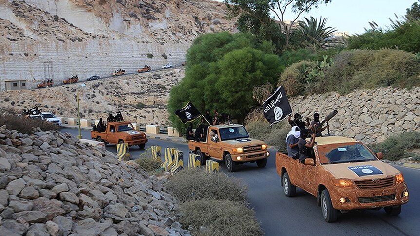 An armed motorcade of the Libyan city of Derna's Islamic Youth Council, who have pledged allegiance to IS, fly black flags.