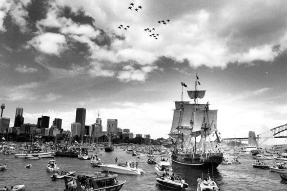 Tall ships arrive in Sydney Harbour, surrounded by hundreds of small boats.