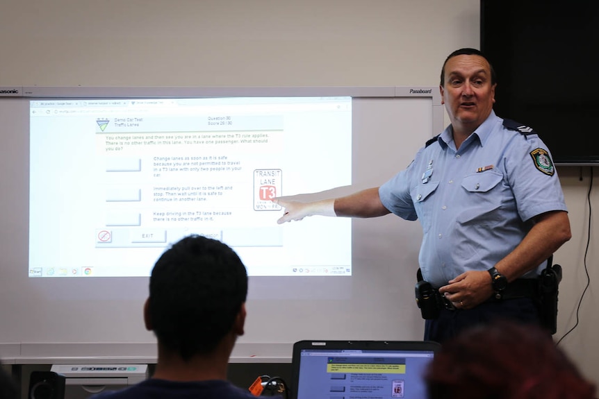 Senior Constable David Henderson in front of big screen