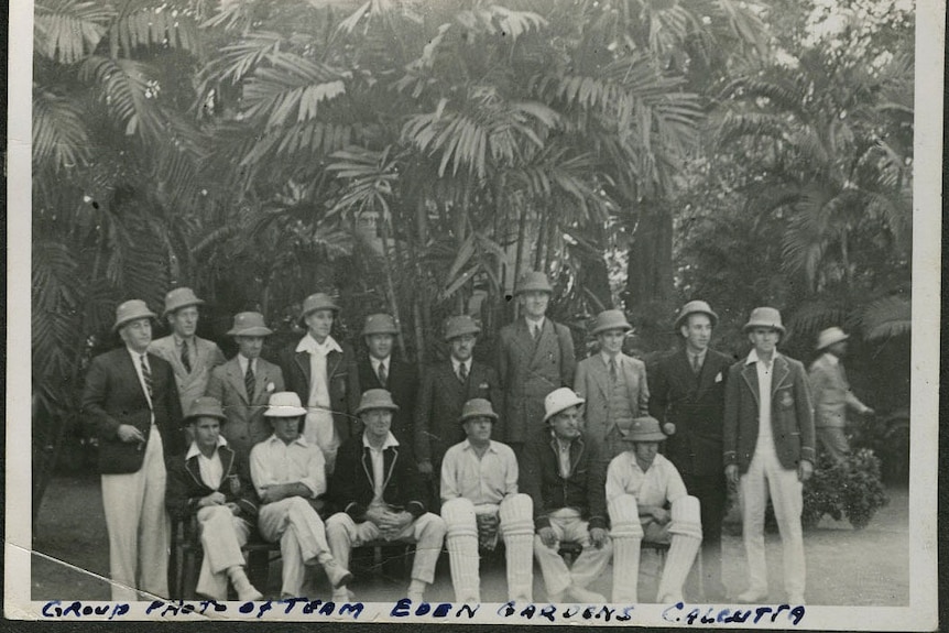 A group of men pose wearing helmets