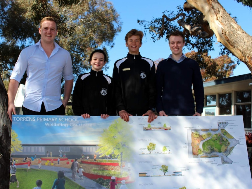 Torrens Primary School captains Harper Stanier and Sam Harding (centre)  with University of Canberra landscape design students Luke Duggan (left) and Chris Norris (right) with the design for the new courtyard at Torrens Primary School.