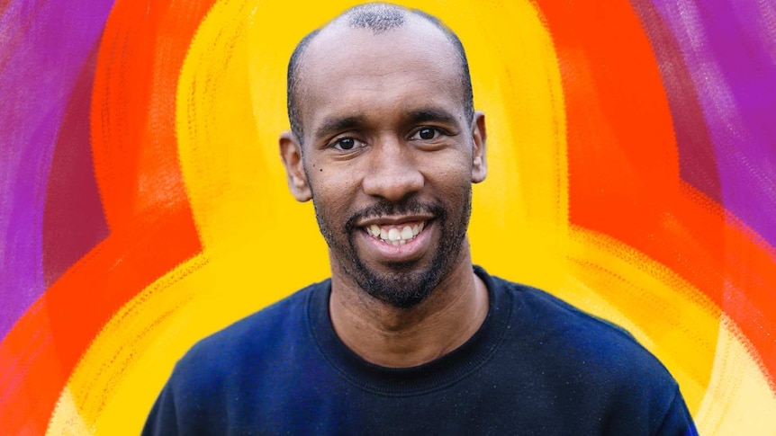 A photo of a man smiling to camera against a colourful illustrated background.