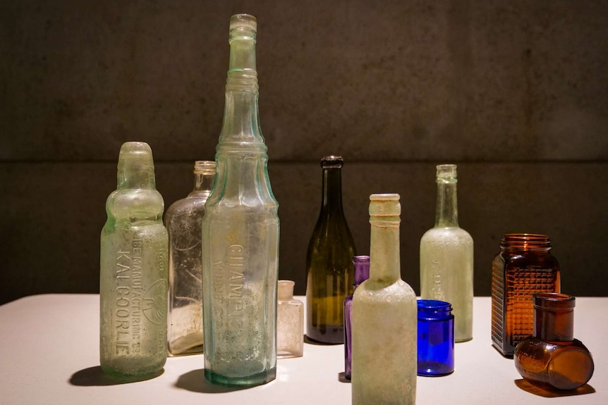 Bottles of different colours on a table.