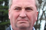 Agriculture Minister Barnaby Joyce standing at a press conference on a farm