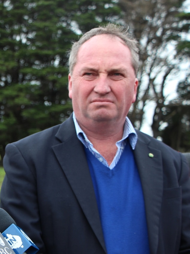 Agriculture Minister Barnaby Joyce standing at a press conference on a farm
