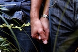 A gay couple hold hands during a symbolic wedding ceremony (Max Rossi, Reuters)