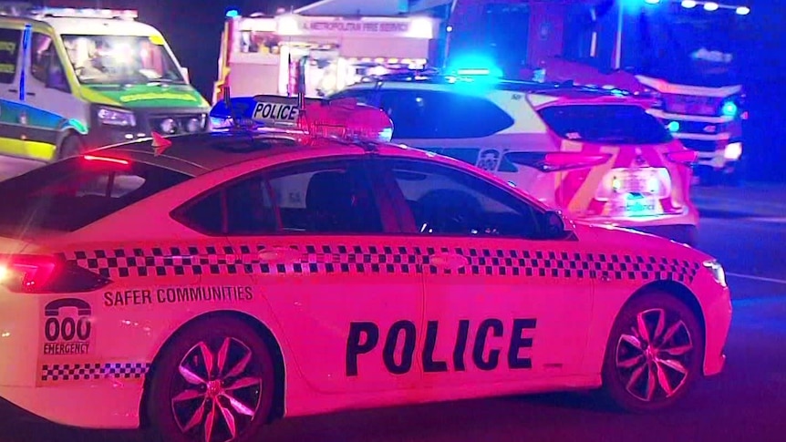 A police car, two ambulances and a fire truck at night