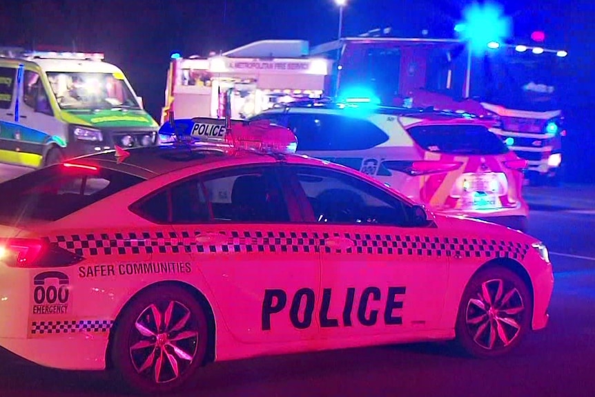 A police car, two ambulances and a fire truck at night