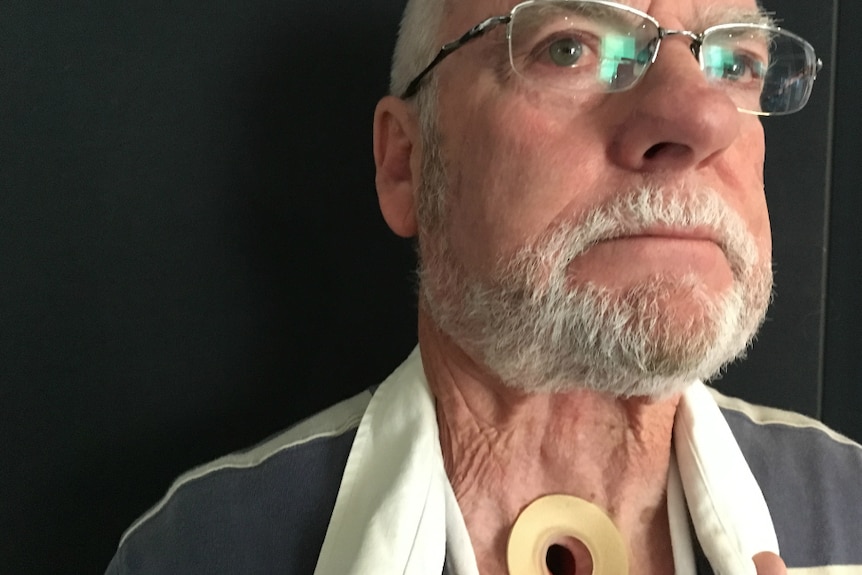 Man who is not smiling has a hole in the neck after a laryngectomy.