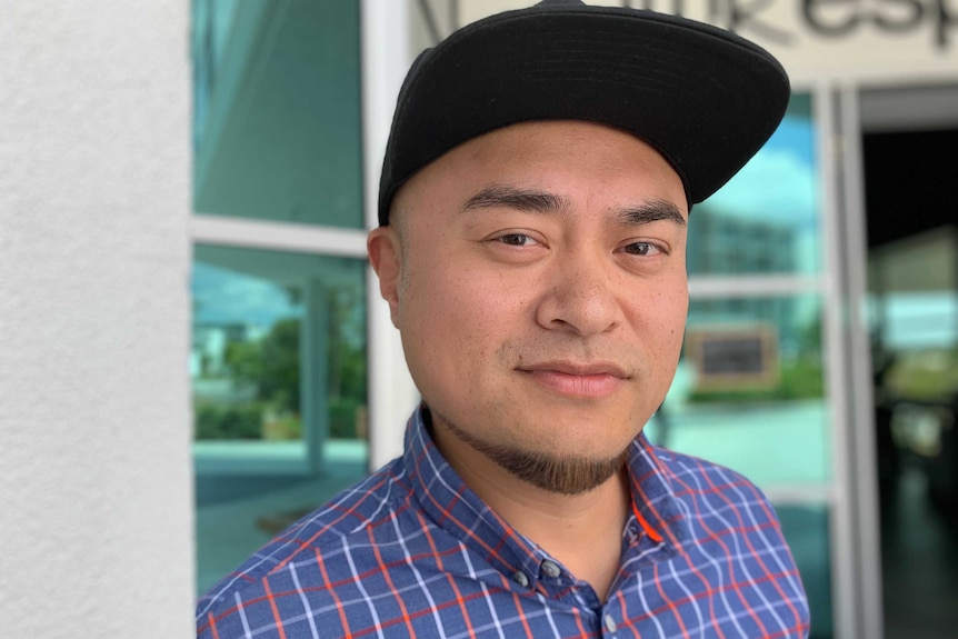 Jun Yu looks at the camera, wearing a cap.