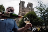 A waitress serves a glass of champagne.