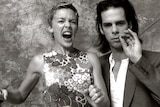 Black and white photo of Kylie Minogue with her mouth open and Nick Cave smoking