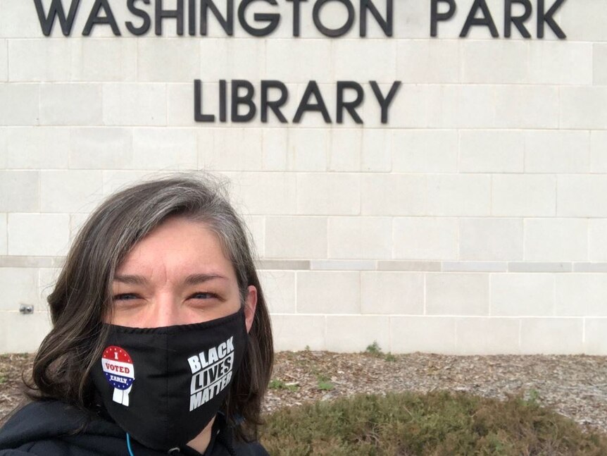 A woman in a Black Lives Matter mask with an 'I Voted Early' sticker on it