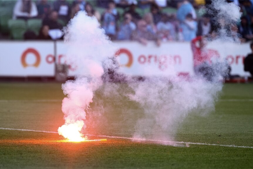 A flare is seen on the field during the A-League Men's football match between Melbourne City and Melbourne Victory.