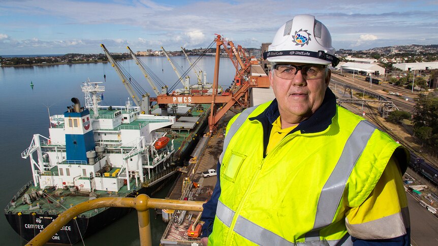 Peter O'Keefe stands on a platform high above a ship loader.