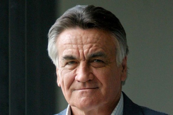 Headshot of an older man, gently smiling at the camera.