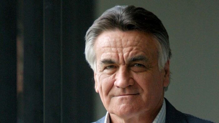 Headshot of an older man, gently smiling at the camera.