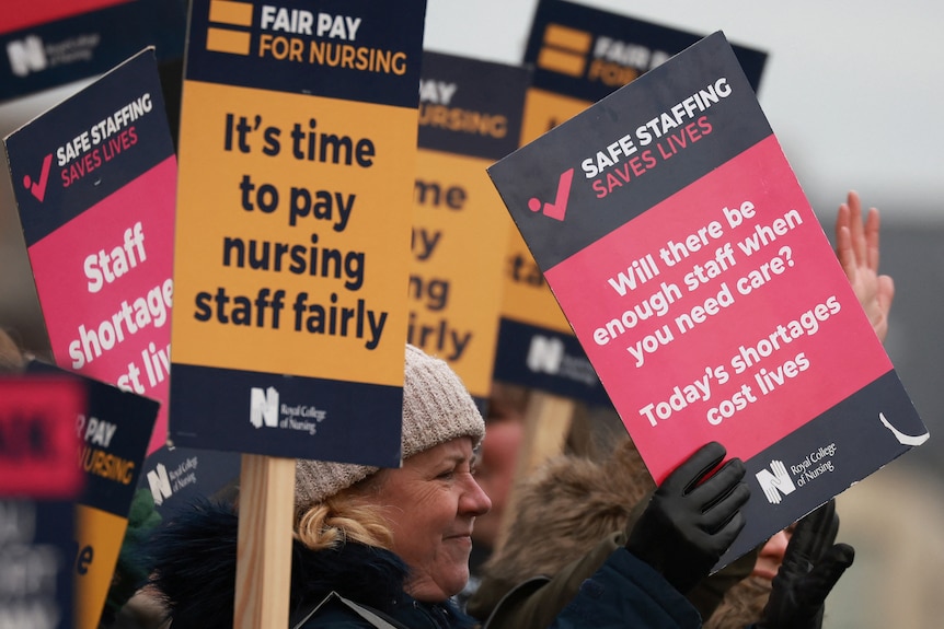 A group holding placards that say "it's time to pay nursing staff failry" and "will there be enough staff when you need care?"