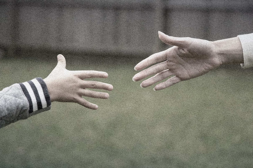 A mother and son stretch to grab each other's hands.