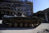 A member of forces loyal to Syria's President Bashar al-Asaad is seen atop of an armoured vehicle