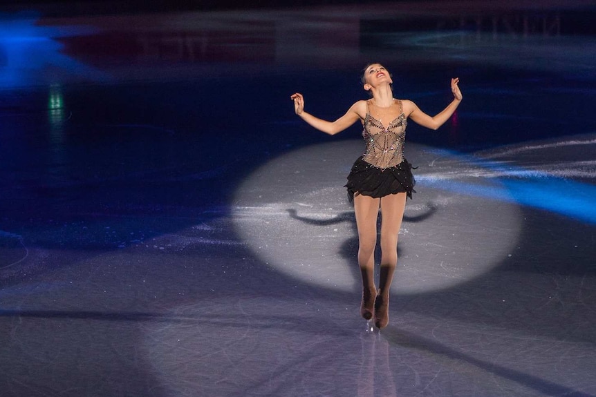 Kailani Craine skating under a spotlight.