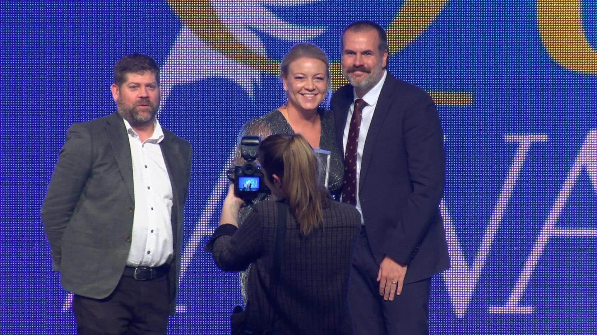 A man and woman posing for a photo on a stage