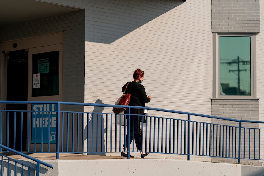 A woman walks down a ramp.