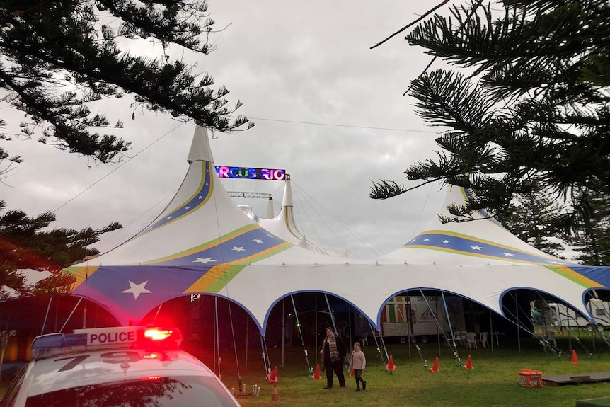 A police car in front of a circus tent.
