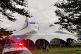 A police car in front of a circus tent.