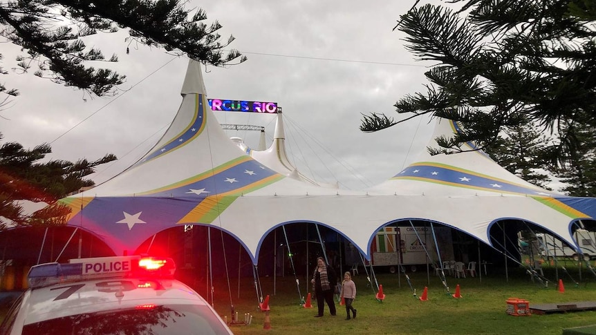 A police car in front of a circus tent.