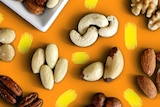 An assortment of nuts arranged side by side on a table top.