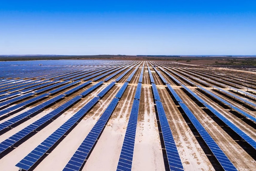 Aerial shot of big solar farm showing rows of panels lined up in a paddock.